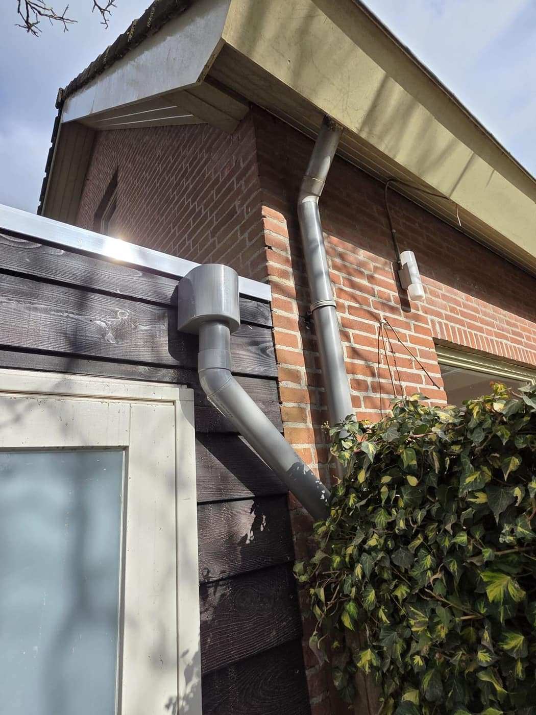 Hemelwaterafvoer langs de gevel, netjes aangesloten op de dakrand.