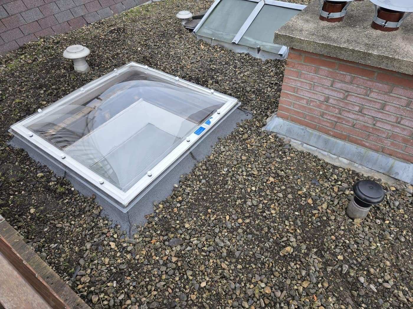 Lichtkoepel in een grinddak, opstand rondom afgewerkt