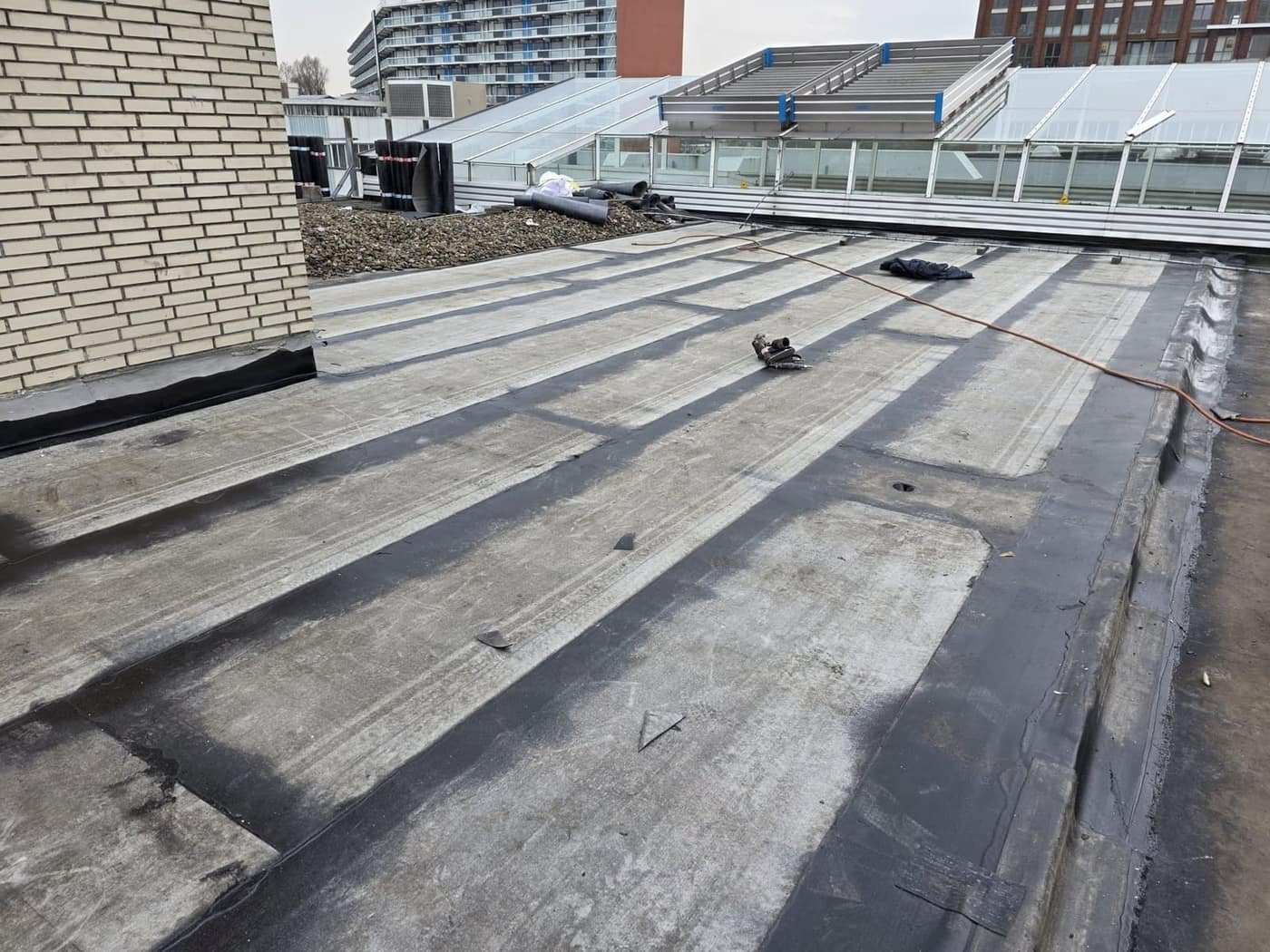 Dakvlak tussen gevel en balustrade, banen strak naast elkaar gelegd