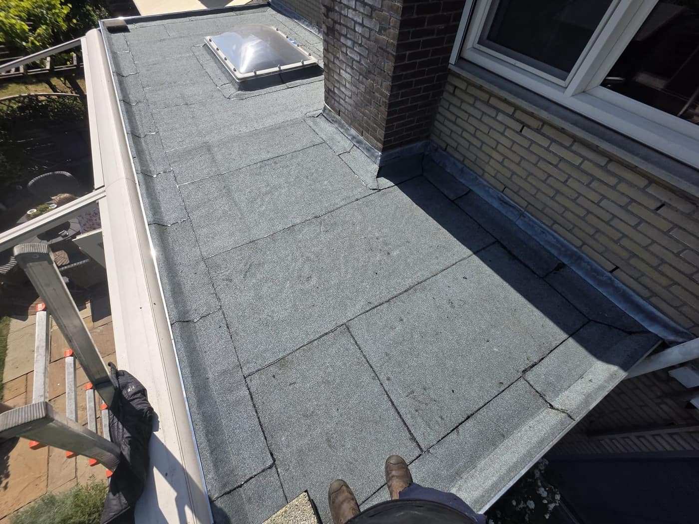 Plat dak van een woning met dakraam, tijdens de uitvoering
