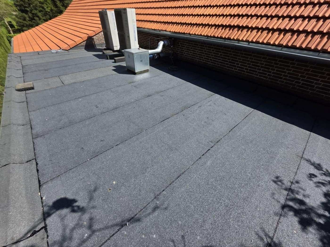 Aansluiting van plat dak op pannendak, met de dakdoorvoeren