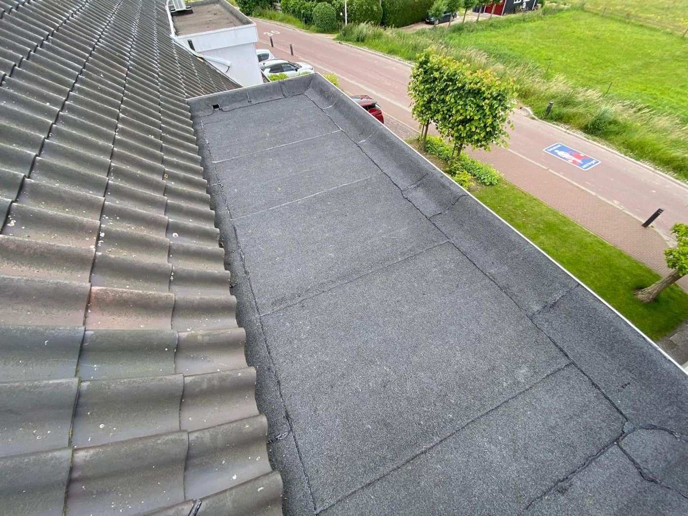 Uitzicht over een afgewerkte dakrand richting de straat